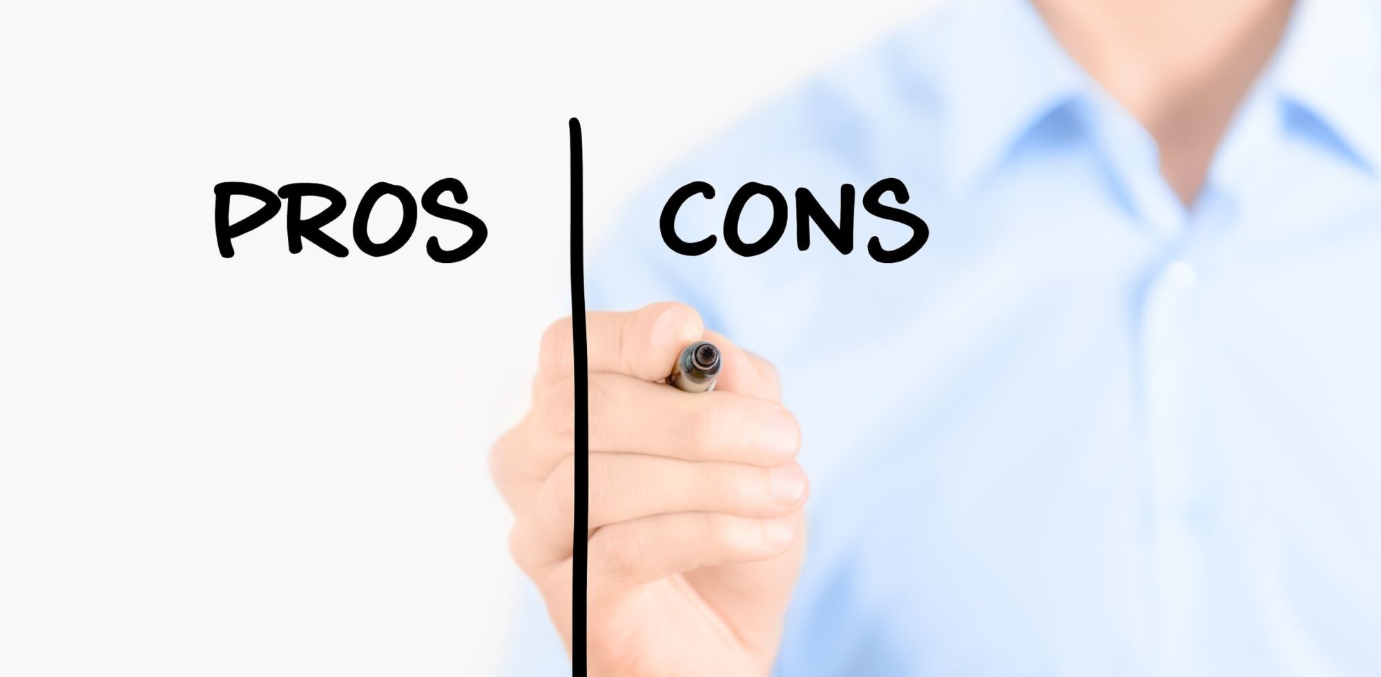 Business person holding a marker and writing pros and cons comparison concept on a clear surface